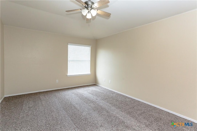 carpeted spare room featuring ceiling fan and baseboards