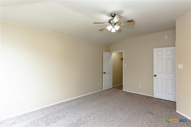 empty room with carpet, visible vents, vaulted ceiling, ceiling fan, and baseboards