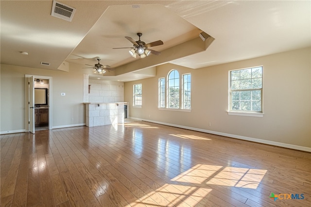 unfurnished living room with light hardwood / wood-style floors, plenty of natural light, and ceiling fan