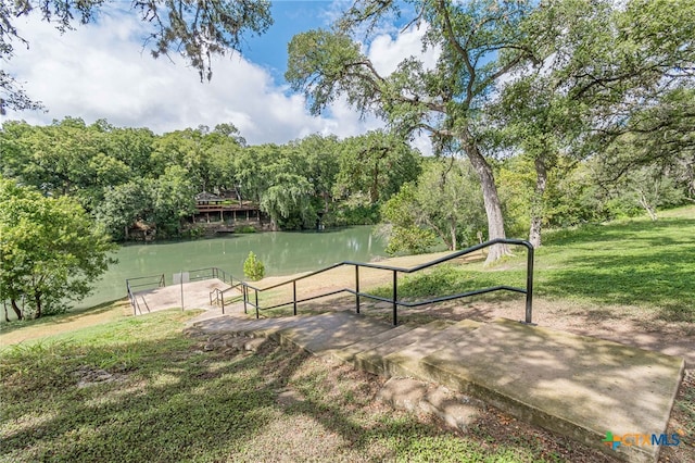 view of home's community with a yard and a water view