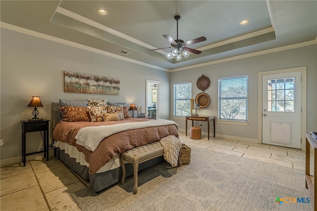 bedroom featuring ceiling fan, crown molding, a tray ceiling, and multiple windows