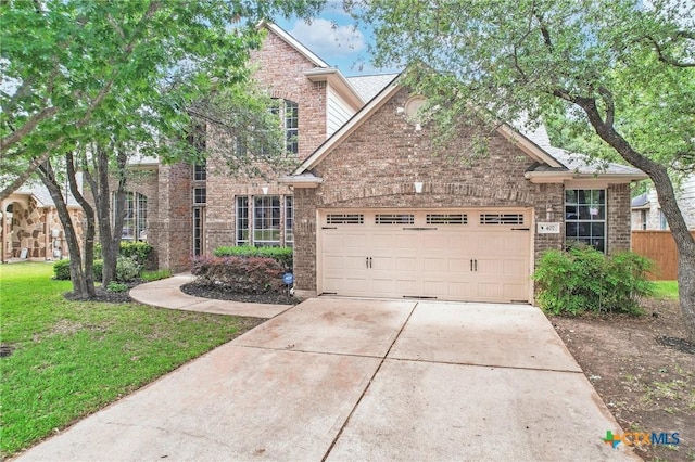 407 Misty Morn Ln, Cedar Park, TX 78613 - view of front facade with an attached garage, driveway, brick siding, and a front yard