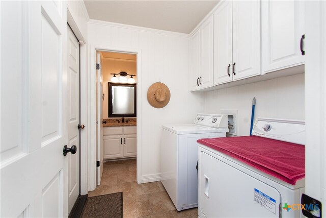 laundry room with sink, cabinets, independent washer and dryer, and crown molding