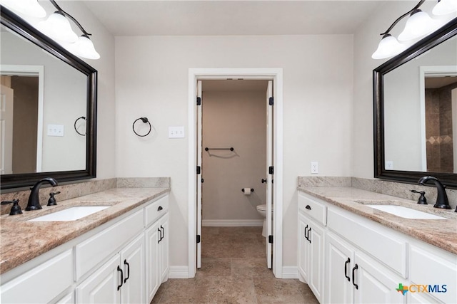 4101 Hickory Rd, Temple, TX 76502 - full bathroom featuring two vanities, toilet, and baseboards
