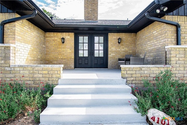 4101 Hickory Rd, Temple, TX 76502 - view of exterior entry with french doors, brick siding, a chimney, and roof with shingles