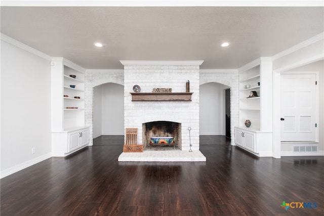 unfurnished living room with a brick fireplace, dark hardwood / wood-style floors, built in features, and crown molding