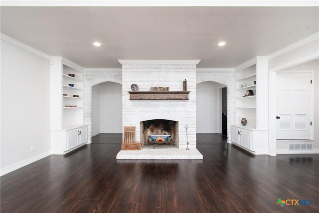 4101 Hickory Rd, Temple, TX 76502 - unfurnished living room featuring built in features, dark wood-style flooring, crown molding, a brick fireplace, and recessed lighting
