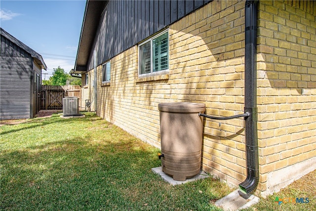 view of side of home with a lawn and central air condition unit