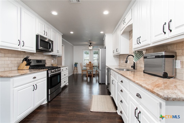 kitchen featuring stainless steel appliances, dark hardwood / wood-style flooring, light stone counters, sink, and white cabinetry