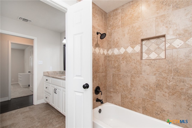 bathroom with vanity, tile patterned floors, and tiled shower / bath