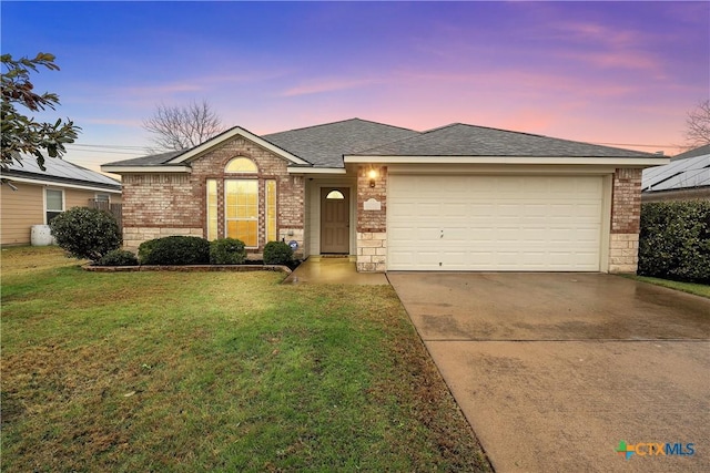 ranch-style home featuring a yard and a garage