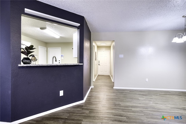 4408 Secretariat Dr, Killeen, TX 76549 - unfurnished room featuring a textured ceiling, wood finished floors, baseboards, a chandelier, and a sink