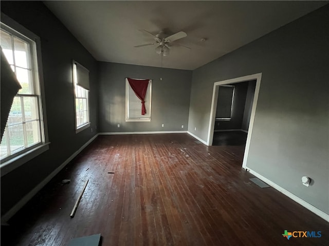 empty room featuring dark wood-type flooring and ceiling fan