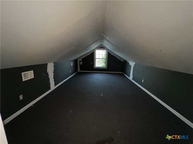 bonus room with lofted ceiling and carpet