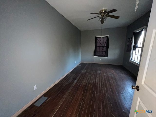 spare room with dark wood-type flooring and ceiling fan