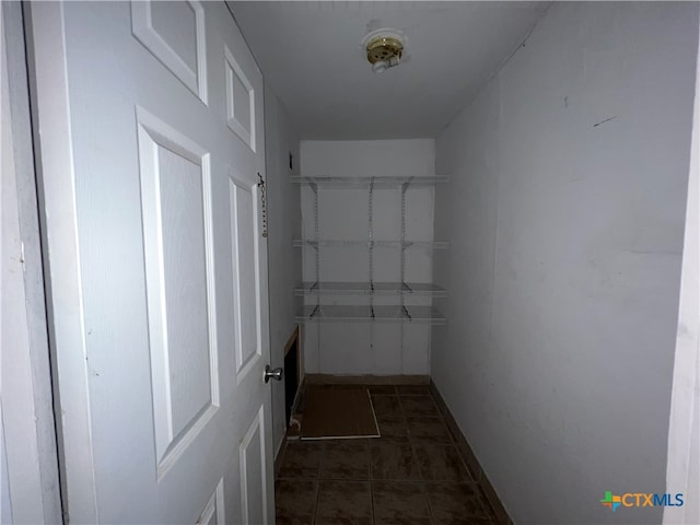 spacious closet featuring dark tile patterned flooring