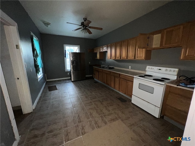 kitchen featuring ceiling fan, stainless steel fridge with ice dispenser, sink, and white range with electric stovetop