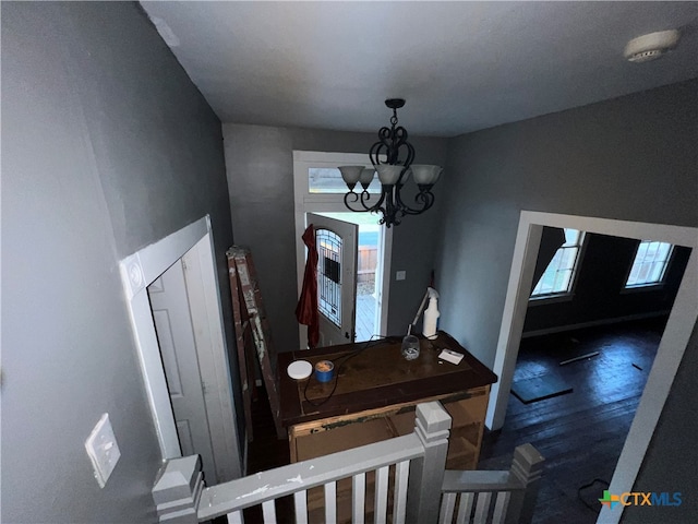 foyer entrance with dark hardwood / wood-style flooring and an inviting chandelier