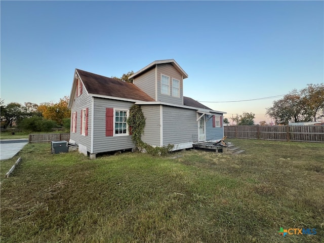 back house at dusk with a lawn