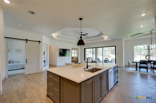 kitchen with a healthy amount of sunlight, light hardwood / wood-style floors, a barn door, and sink