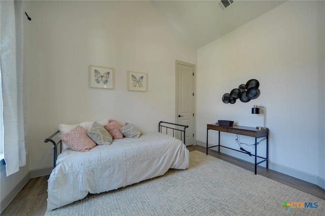 bedroom with light hardwood / wood-style floors and vaulted ceiling