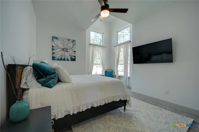 carpeted bedroom with ceiling fan and vaulted ceiling