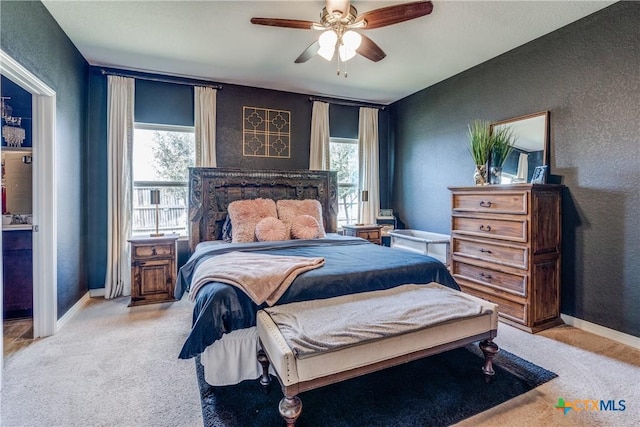 bedroom with ceiling fan, a textured wall, baseboards, and carpet