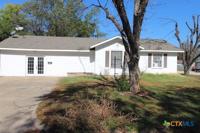 view of front of property with french doors and a front lawn