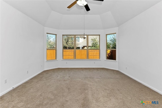 carpeted empty room with baseboards, a ceiling fan, and vaulted ceiling