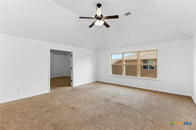 carpeted spare room featuring visible vents, baseboards, ceiling fan, and vaulted ceiling