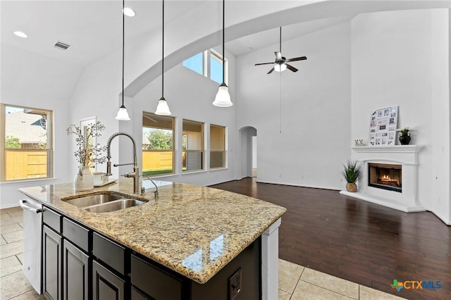 kitchen featuring visible vents, ceiling fan, open floor plan, plenty of natural light, and a sink