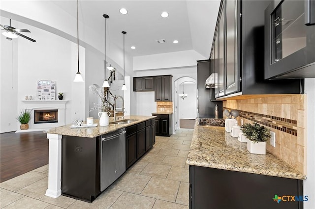 kitchen with light tile patterned floors, visible vents, arched walkways, a sink, and dishwasher