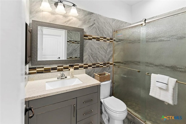 full bathroom featuring tasteful backsplash, a shower stall, vanity, and toilet