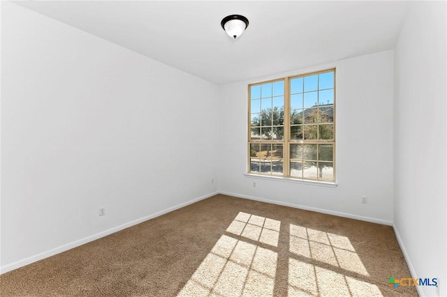 carpeted spare room with baseboards