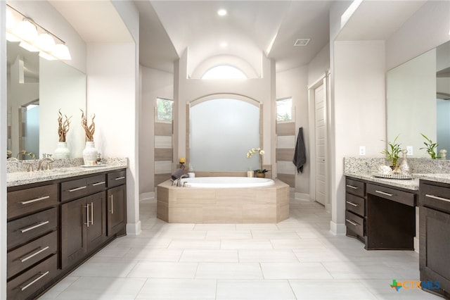 bathroom with vanity, tile patterned flooring, and a relaxing tiled tub