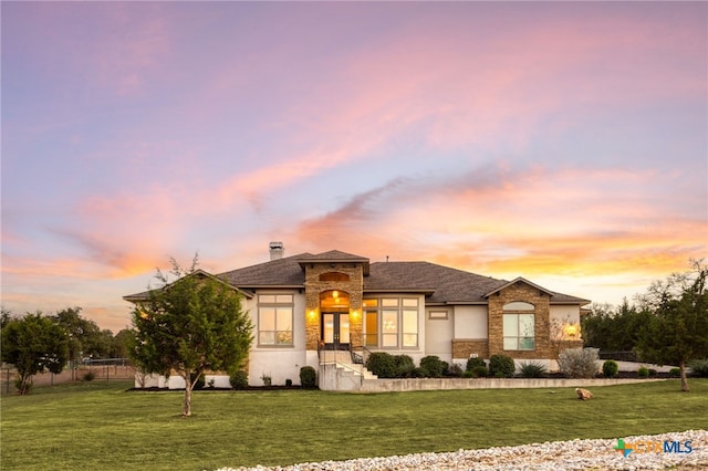 prairie-style home featuring a lawn and french doors