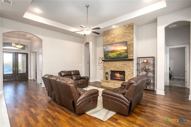 living room with french doors, dark hardwood / wood-style floors, a raised ceiling, and ceiling fan