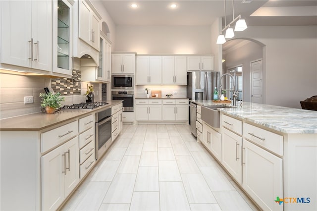 kitchen with white cabinets, stainless steel appliances, and decorative light fixtures