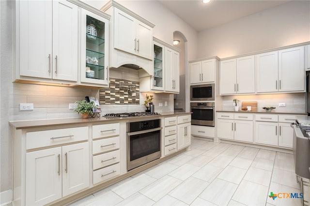 kitchen with appliances with stainless steel finishes, tasteful backsplash, and white cabinetry