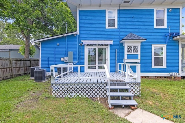 1200 4th St, Palacios, TX 77465 - back of property featuring a wooden deck and central AC unit