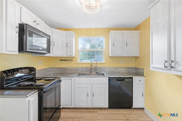 1200 4th St, Palacios, TX 77465 - kitchen with black appliances, a sink, and white cabinetry