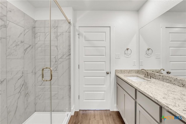 2310 Healy Dr, Temple, TX 76502 - bathroom featuring a marble finish shower, wood finished floors, and vanity