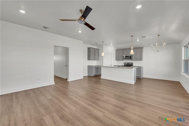 2310 Healy Dr, Temple, TX 76502 - unfurnished living room featuring a sink, baseboards, visible vents, and wood finished floors