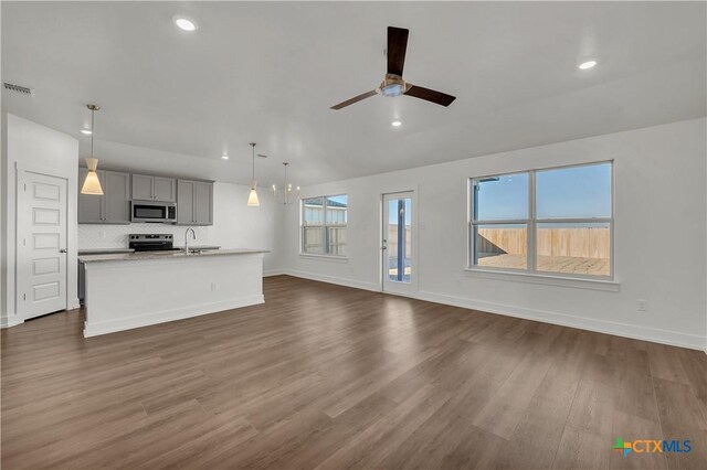 2310 Healy Dr, Temple, TX 76502 - unfurnished living room with baseboards, dark wood finished floors, recessed lighting, and a sink