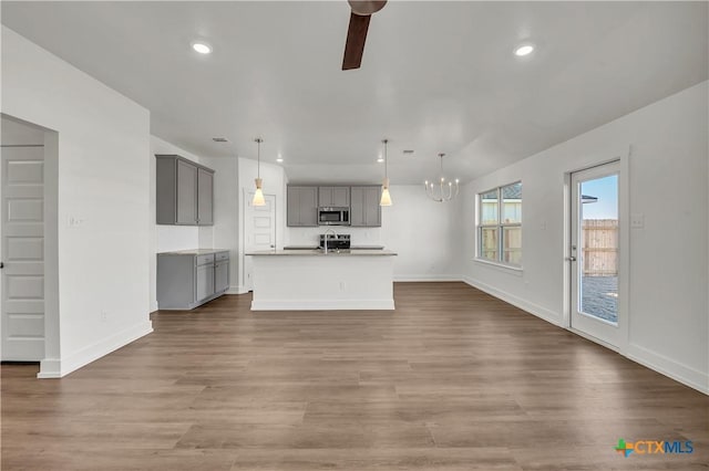 2310 Healy Dr, Temple, TX 76502 - unfurnished living room with baseboards, wood finished floors, and ceiling fan with notable chandelier
