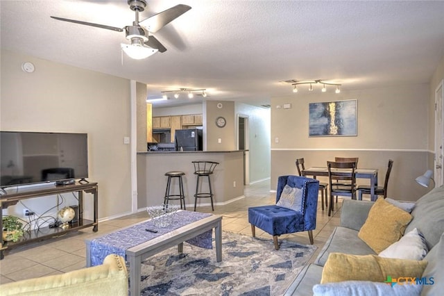 tiled living room featuring ceiling fan and a textured ceiling