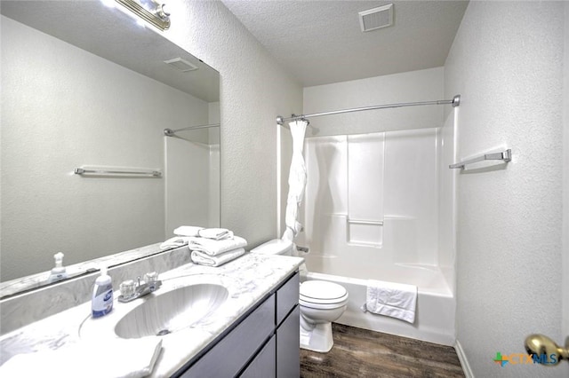 full bathroom featuring toilet, wood-type flooring, vanity, a textured ceiling, and shower / bathing tub combination