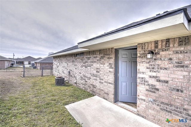 doorway to property with a yard and central AC