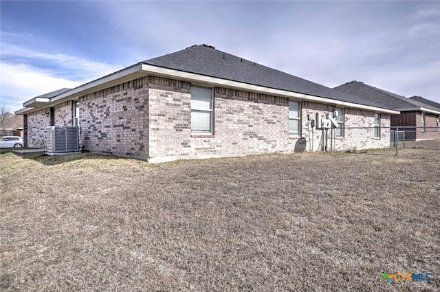 view of side of home featuring a yard and central AC unit