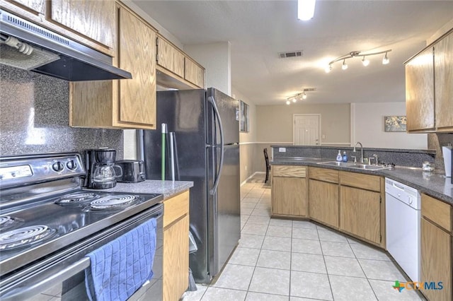 kitchen with sink, light tile patterned flooring, black appliances, and dark stone counters